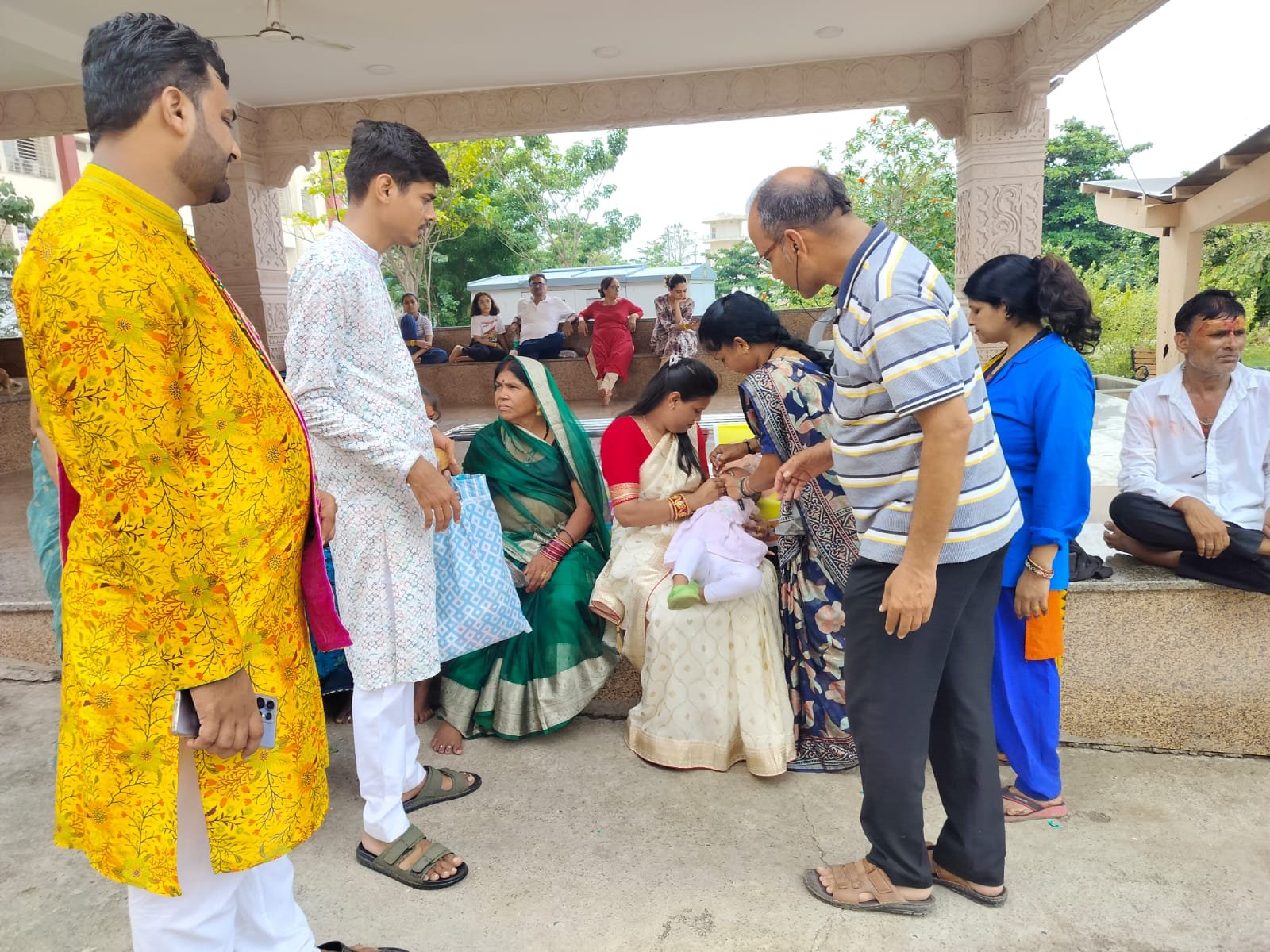 उज्जैन के श्री महाकाल लोक में राष्ट्रीय पल्स पोलियो अभियान के दौरान स्वास्थ्यकर्मी श्रद्धालुओं के बच्चों को पोलियो की दवा पिलाते हुए।