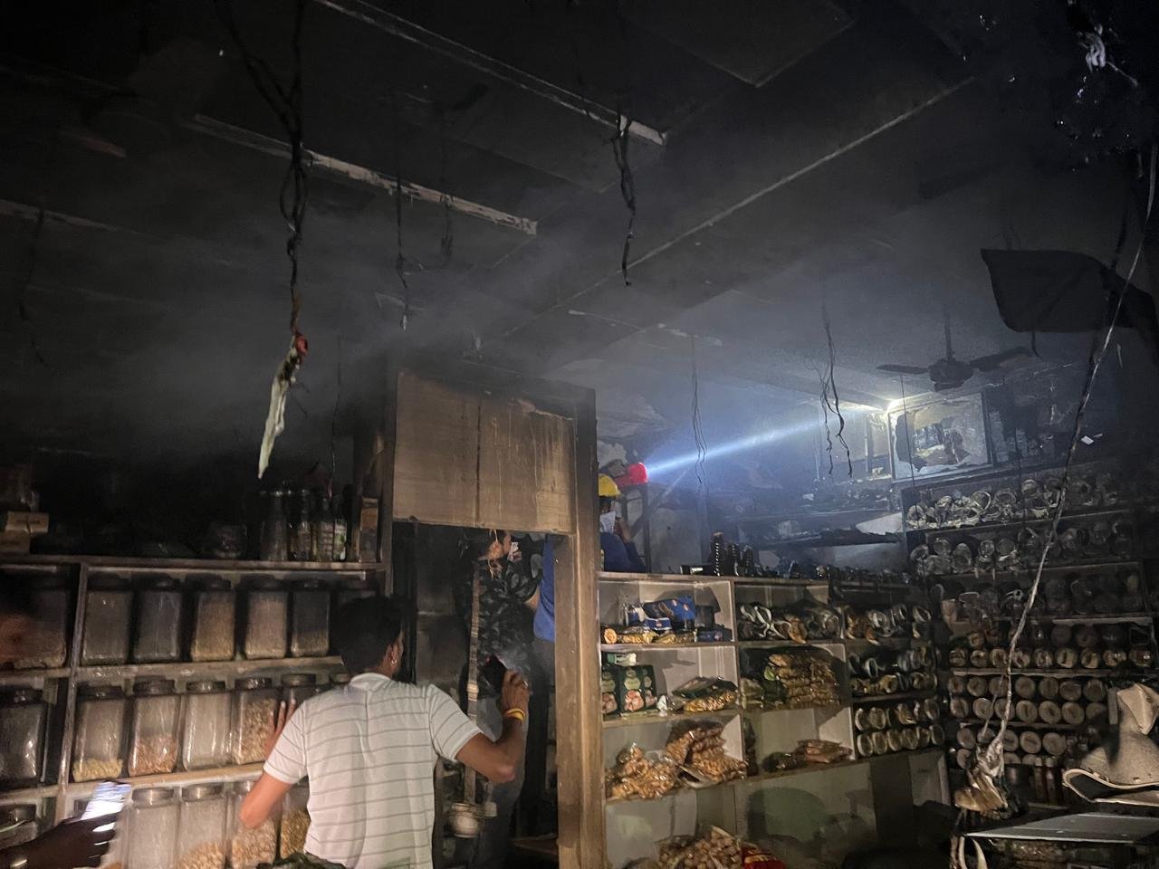 उज्जैन के फ्रीगंज क्षेत्र में ड्राई फ्रूट्स और किराना दुकान में लगी आग पर काबू पाती फायर ब्रिगेड की टीम।