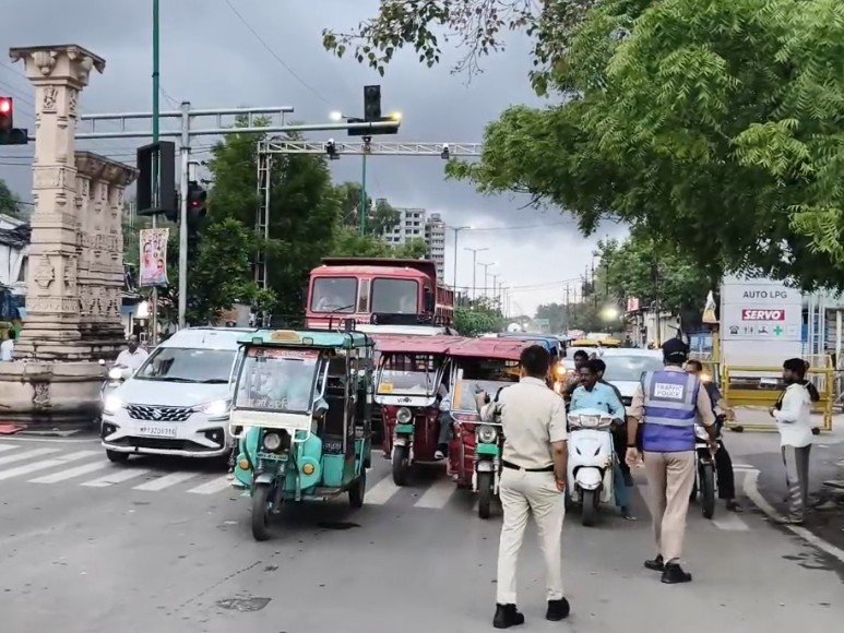 उज्जैन के व्यस्त चौराहे पर ट्रैफिक व्यवस्था संभालते पुलिसकर्मी और वाहन